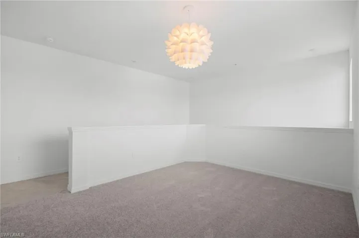Unfurnished room with light colored carpet and baseboards