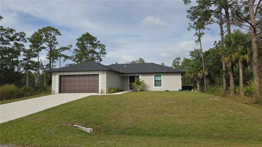 Ranch-style house with stucco siding, a front yard, concrete driveway, and an attached garage