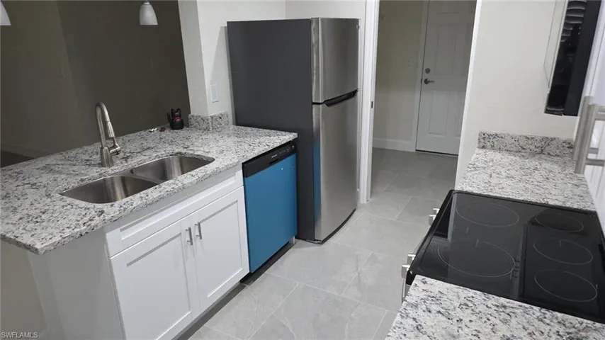 Kitchen with white cabinetry, light stone countertops, electric stove, dishwashing machine, and a peninsula