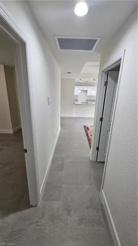 Hall featuring baseboards and a textured wall