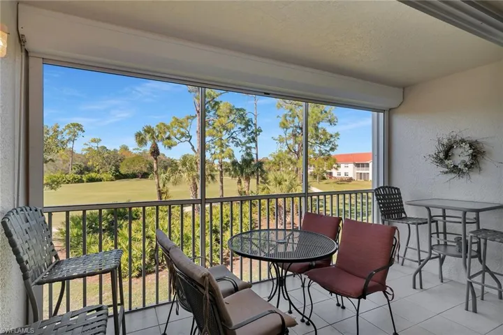 Sunroom featuring view of golf course