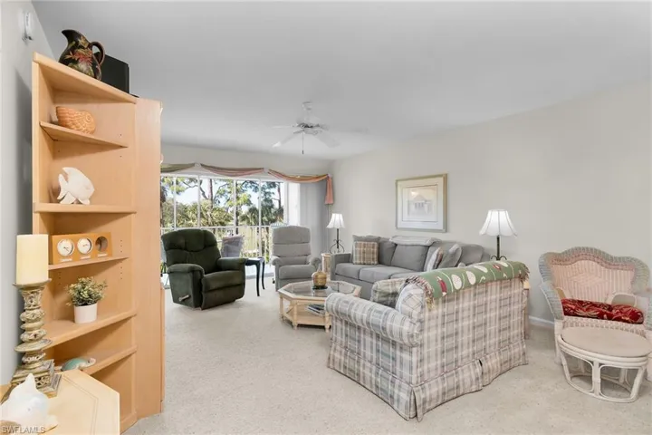 Living area with ceiling fan and light colored carpet