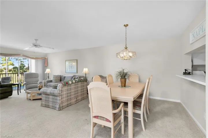 Dining space featuring light colored carpet, a ceiling fan, and hanging lights