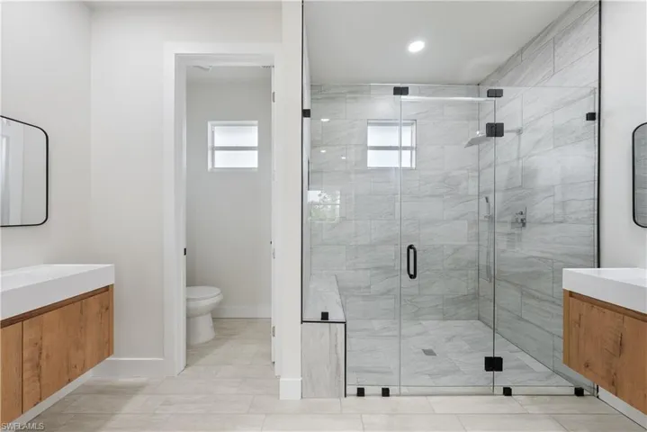 Full bath with vanity, healthy amount of natural light, and a shower stall