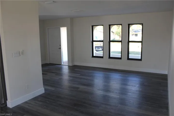 Spare room featuring dark wood-type flooring