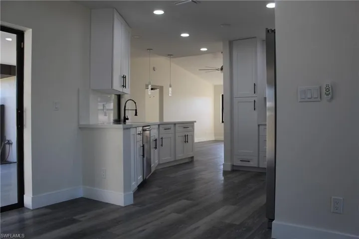 Hall with sink and dark wood-type flooring