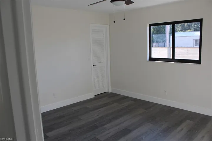 Spare room featuring ceiling fan and dark hardwood / wood-style floors