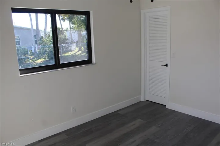 Unfurnished bedroom with dark hardwood / wood-style floors and a closet