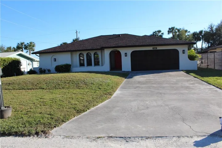 Ranch-style house with a garage and a front yard