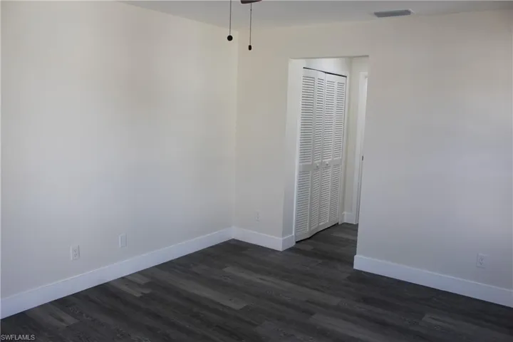 Empty room with dark wood-type flooring