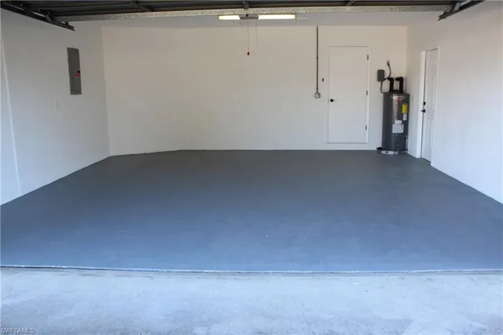 Garage featuring electric panel and electric water heater