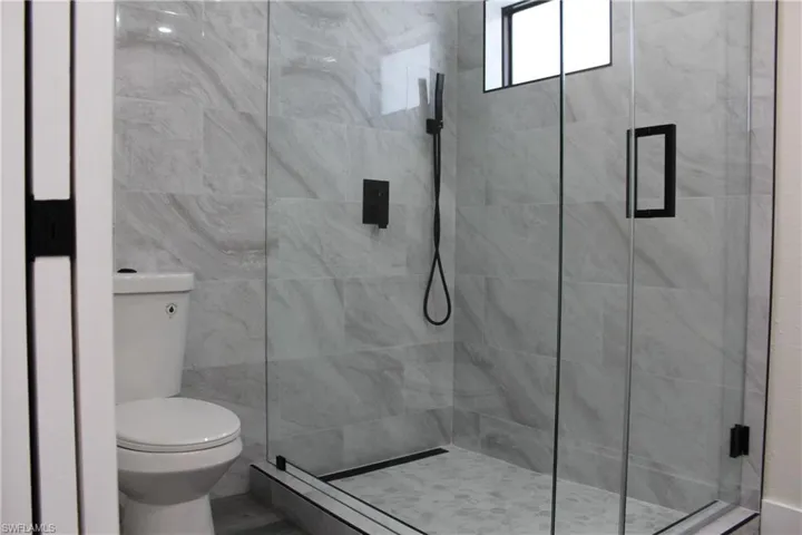 Bathroom featuring walk in shower and toilet