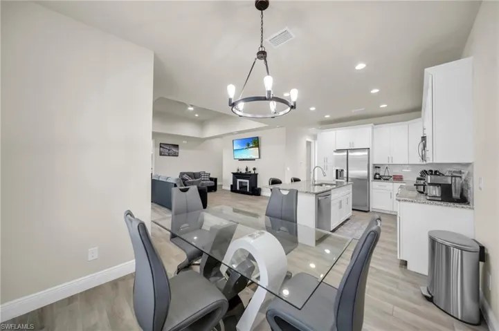 Dining room with visible vents, recessed lighting, a notable chandelier, and light wood-style floors