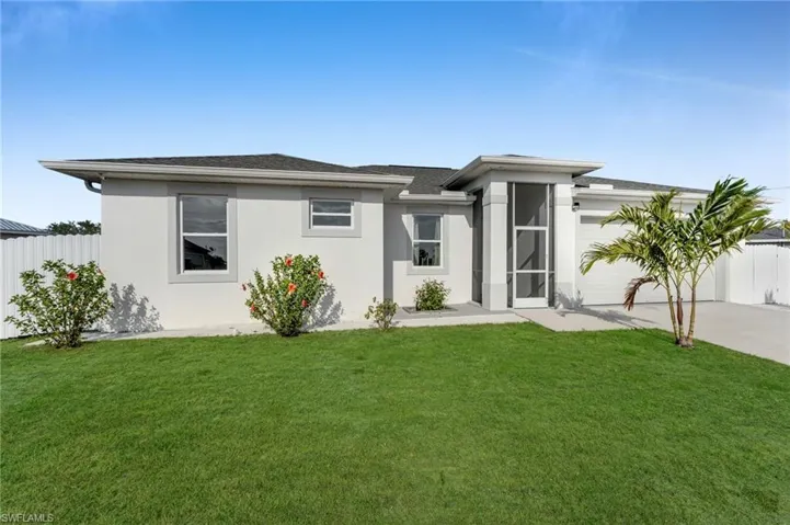 View of front of house with a garage, fence, a front lawn, and concrete driveway