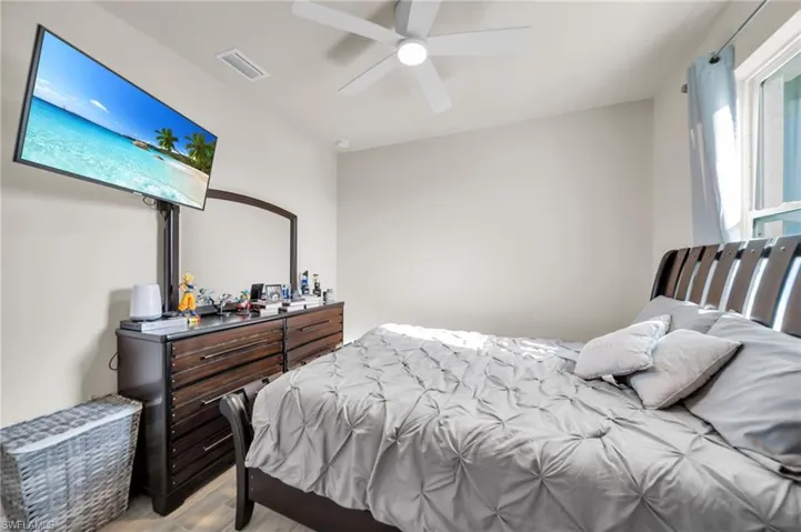 Bedroom featuring wood finished floors, visible vents, and ceiling fan