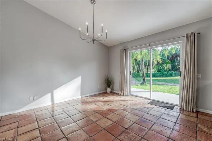 Unfurnished room with vaulted ceiling and a chandelier