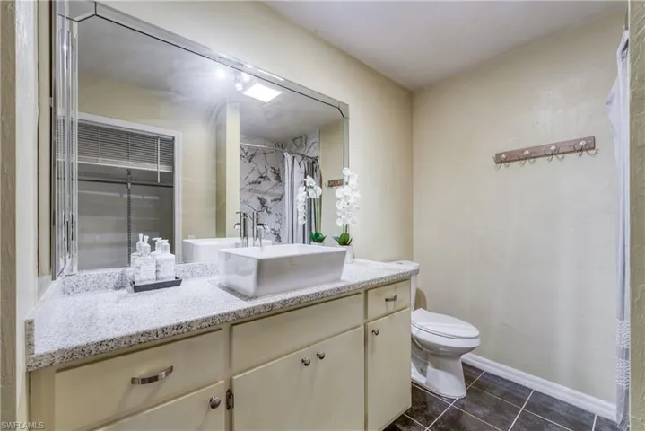 Bathroom with vanity, toilet, a shower with curtain, and tile patterned floors