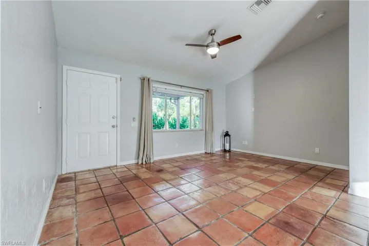 Unfurnished room featuring vaulted ceiling, light tile patterned floors, and ceiling fan