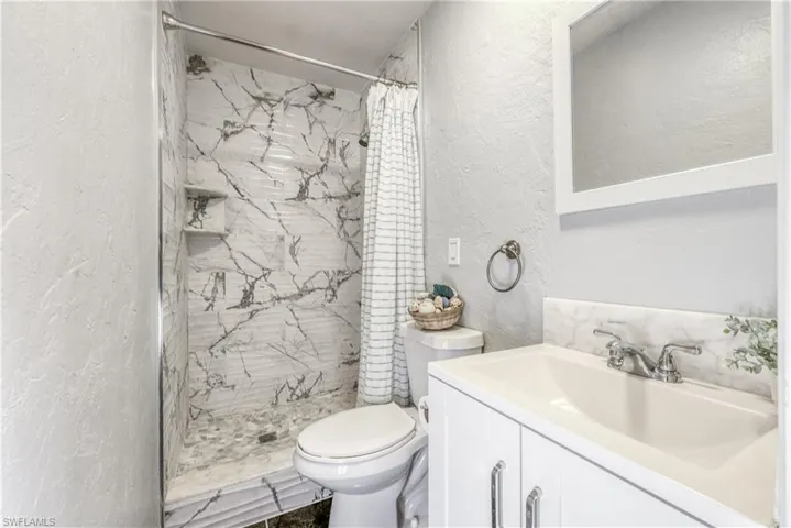 Bathroom featuring vanity, a shower with curtain, and toilet