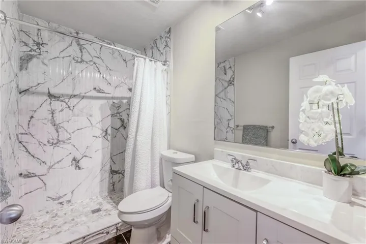 Bathroom featuring vanity, toilet, and walk in shower