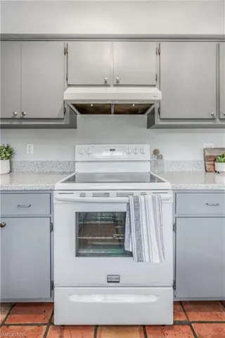 Kitchen with white electric range and gray cabinets
