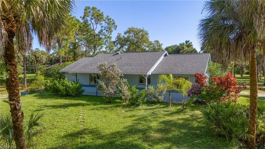 Back of house with a yard