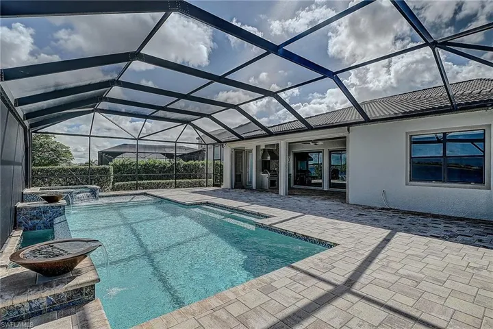 View of swimming pool featuring a patio and glass enclosure