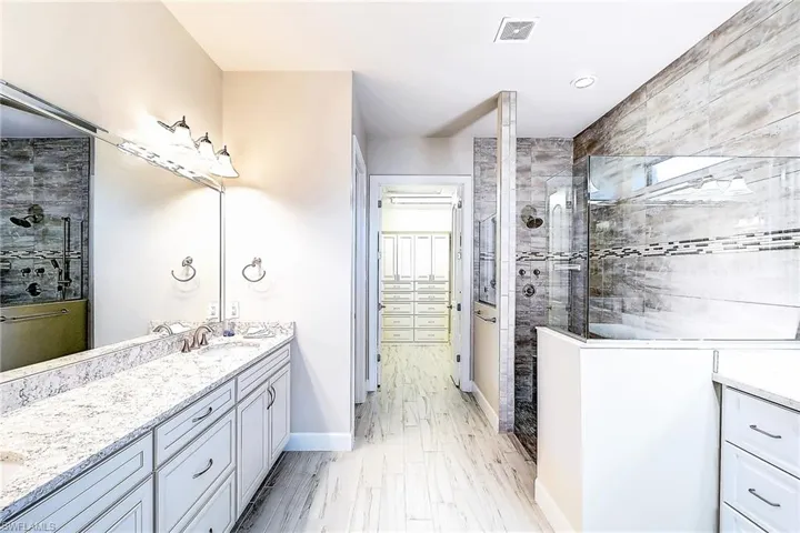 Bathroom featuring vanity and tiled shower