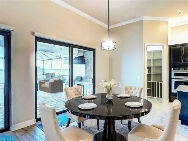 Dining space with crown molding and light hardwood / wood-style flooring