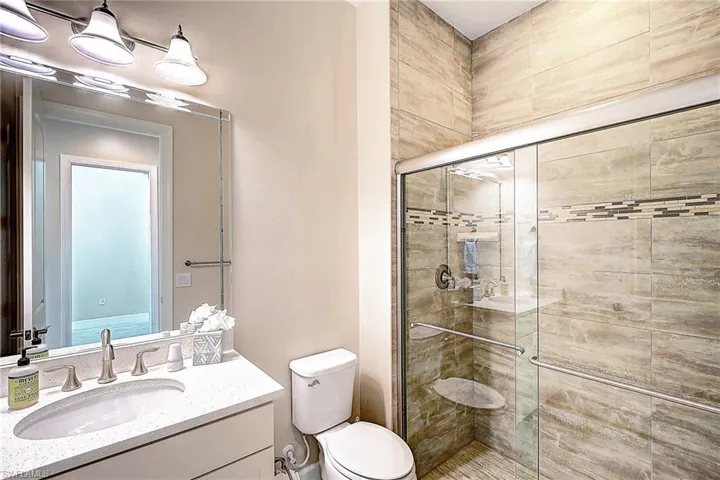 Bathroom with vanity, toilet, and a shower with door