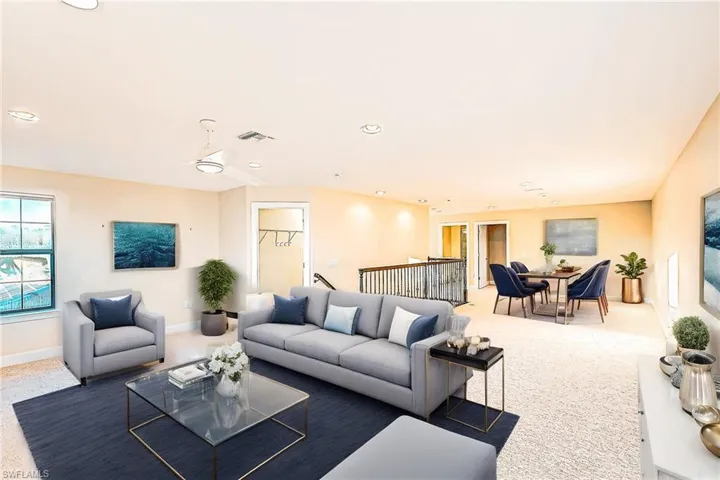 Carpeted living room with ceiling fan