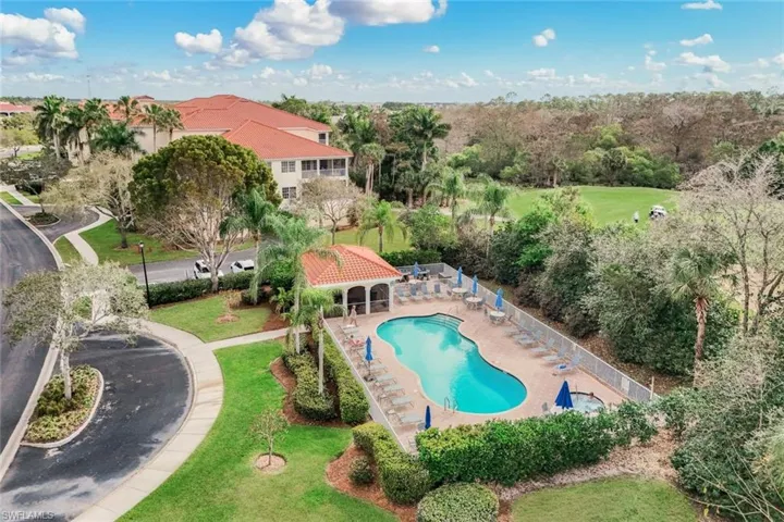 Aerial view of a pool area and a tree filled landscape