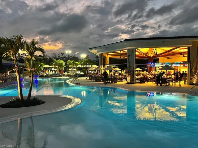 Pool at dusk featuring a community pool and a patio