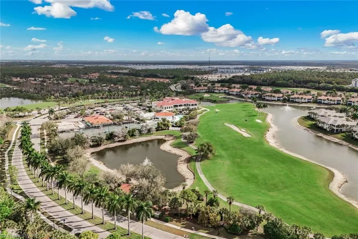Aerial perspective of suburban area featuring a large body of water and a golf club