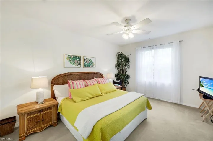 Bedroom featuring light colored carpet and ceiling fan