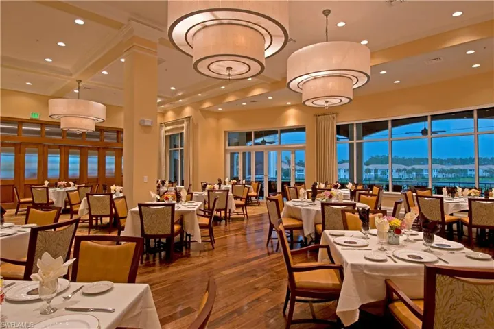 Dining room with dark wood-style flooring, recessed lighting, and a high ceiling