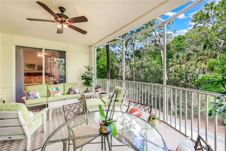 Sunroom / solarium with outdoor lounge area, ceiling fan, and view of scattered trees