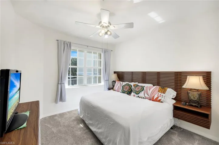 Bedroom with a ceiling fan and carpet