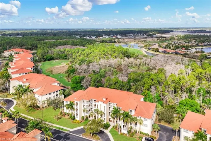 Aerial view of residential area with a golf course and a large body of water