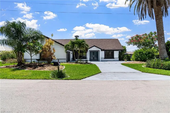 Single story home with driveway, a front lawn, and roof with shingles