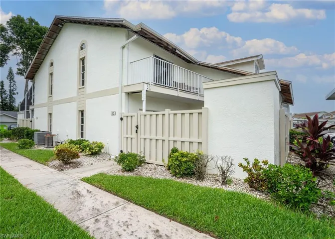 View of side of home featuring a balcony and central AC unit
