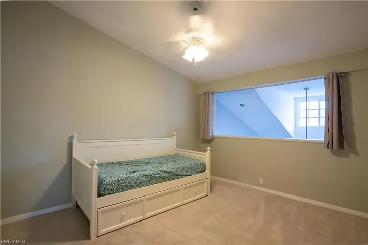Bedroom with carpet and vaulted ceiling