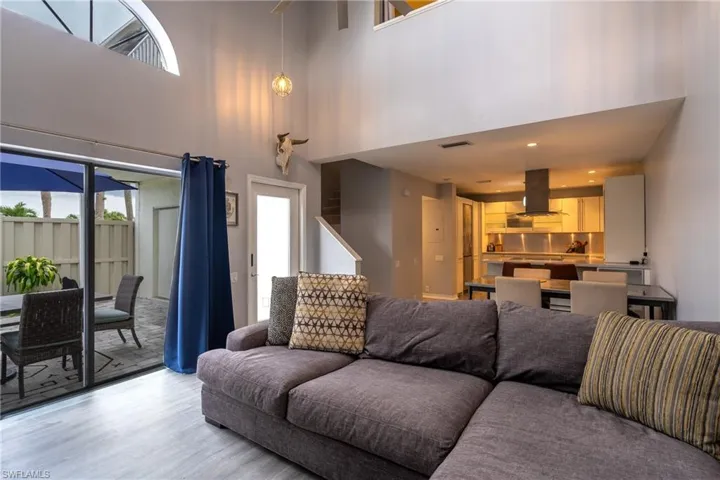 Living room featuring light hardwood / wood-style floors, a high ceiling, and plenty of natural light