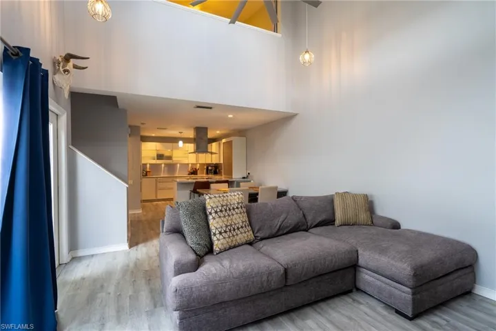 Living room with a high ceiling and light hardwood / wood-style floors