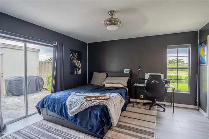 Bedroom with access to exterior, multiple windows, light hardwood / wood-style flooring, and ceiling fan
