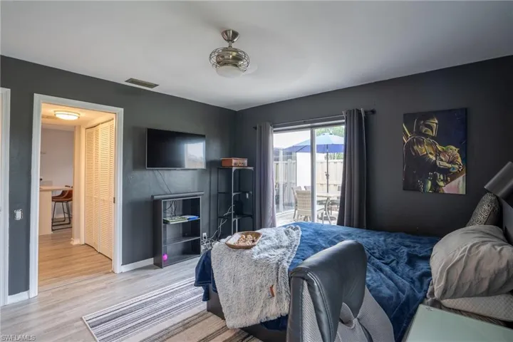 Bedroom with access to exterior and hardwood / wood-style flooring