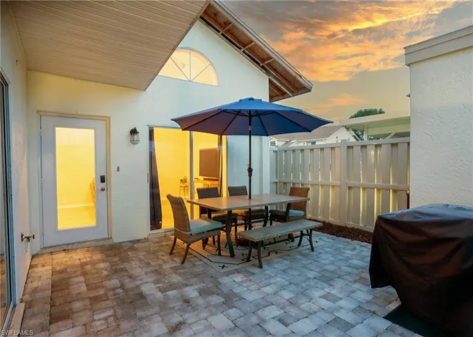 Patio terrace at dusk featuring a grill
