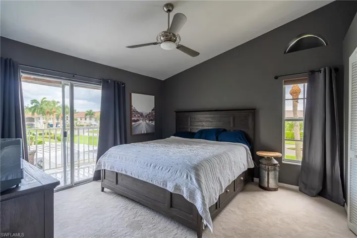 Bedroom with access to outside, ceiling fan, lofted ceiling, and light colored carpet
