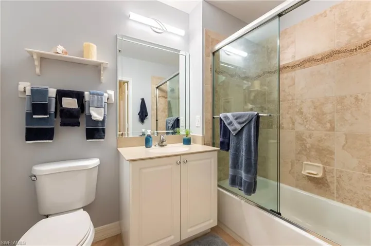 Bathroom featuring vanity and shower / bath combination with glass door
