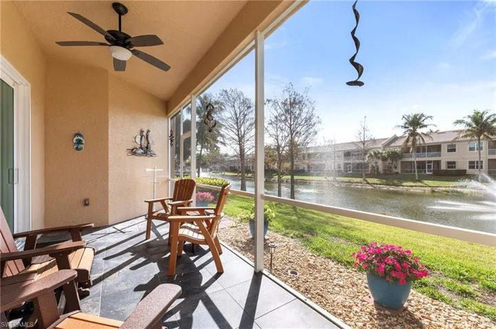 Sunroom / solarium featuring ceiling fan, a water view, and lofted ceiling